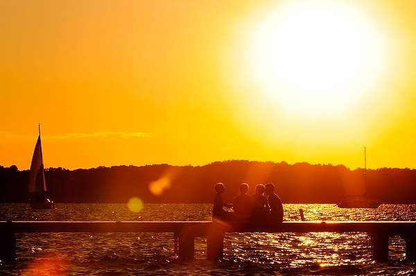 As the sun sets, UW students and members of the Madison community enjoy a cool summer evening at the Memorial Union Terrace on Lake Mendota.