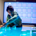 A middle schooler at the New York Hall of Science moves blocks on a gaming table as computers beneath stream data on game and learning behavior to researchers at UW-Madison. Photo: Andrew Kelly/New York Hall of Science