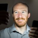 Justin Vandenbroucke, assistant professor of physics, is pictured illuminated by the light from a pair of smartphones in Chamberlin Hall at the University of Wisconsin-Madison campus on Sept. 2, 2014. Vanderbroucke has created a pocket cosmic-ray detector app, called DECO, which uses the image sensor of a cell phone camera to detect cosmic rays and other energetic subatomic particles.