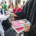 Volunteers distribute copies of Go Big Read’s 2014-15 selection, “I Am Malala,” to UW students following the Chancellor’s Convocation.