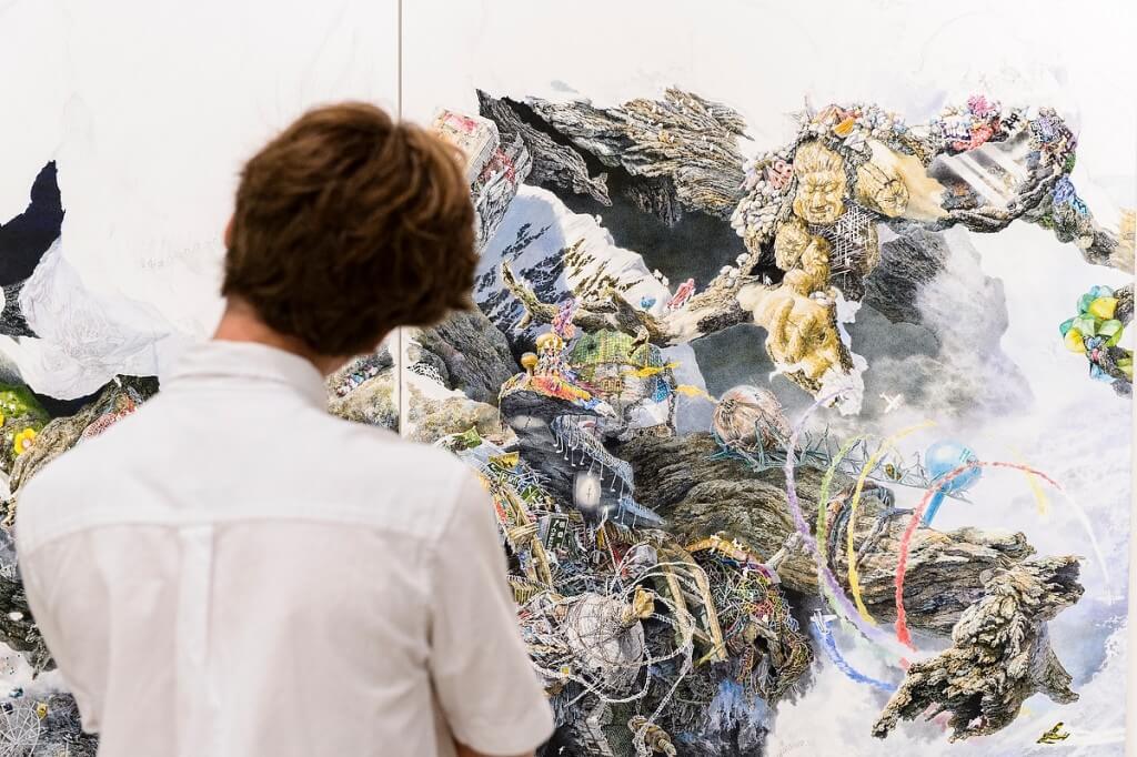 A visitor to the Chazen Museum of Art cocks her head as she studies a massive — and amazingly detailed — drawing, a work-in-progress by Manabu Ikeda, an artist in residence.