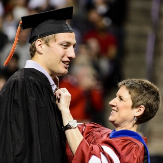 Steve Gerber is one of numerous graduates to receive a last-minute primping from Sarah Pfatteicher, associate dean for academic affairs in the College of Agricultural and Life Sciences.