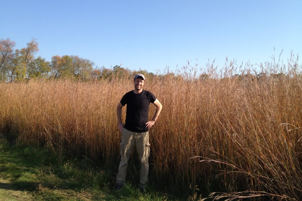 Peter Blank standing in front of a monoculture of Big Bluestem.