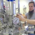 Fritz Schomburg, founder of Lytic Solutions in Madison, with one of the firm's fermenters, where bacteria grow and produce protein for use by pharmaceutical firms or customers in the biomedical industry.