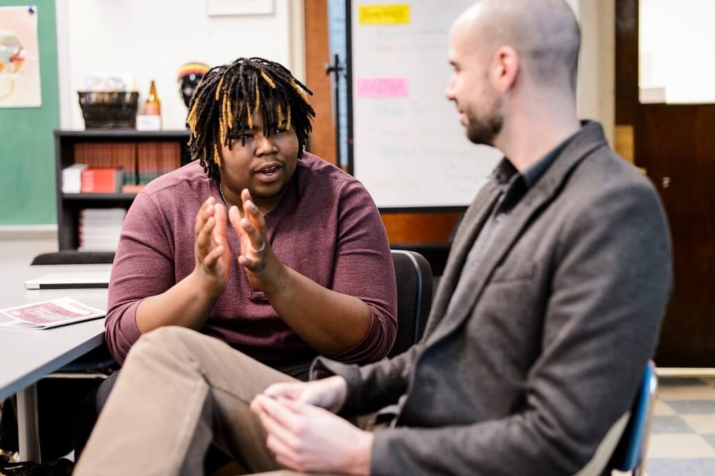 Manuel Herrero-Puertas, right, program coordinator for UW–Madison's Great World Texts in Wisconsin, talks with student Richard Lafford at New Horizons for Learning, a charter school based at Shorewood High School near Milwaukee.