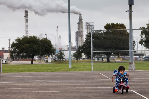 Chrisangel Nieto, age 3, rode his tricycle in front of the Valero refinery in Houston. This refinery processes almost 7 million tons of carbon per year, most of which will end up in the atmosphere as carbon dioxide.