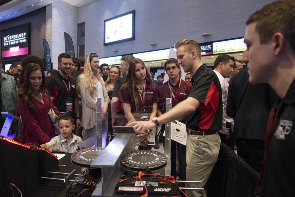 UW-Madison mechanical engineering senior Sidney Smith demonstrates the BadgerLoop Halbach wheels at the team’s exhibit booth during the second day of SpaceX’s Hyperloop Pod Competition Design Weekend. The powerful magnetic wheels spin along both sides of the Hyperloop track’s center rail, stabilizing the levitating transport pod and propelling it down the Hyperloop track. 