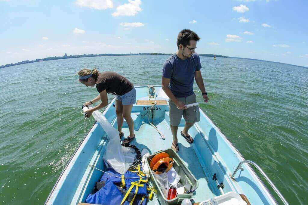 Center for Limnology grad student Jake Walsh and UW–Madison undergrad Carly Broshat use plankton nets to take samples of Daphnia pulicaria and spiny water flea in Lake Mendota. 