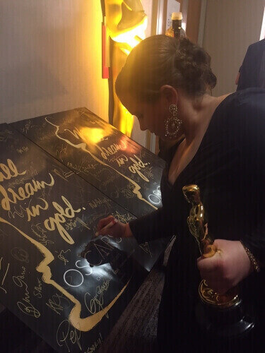 UW-Madison alumna Nicole Rocklin, seen signing a poster backstage, was one of the producers of the movie "Spotlight," which won Best Picture at the 88th Academy Awards on Feb. 28. 