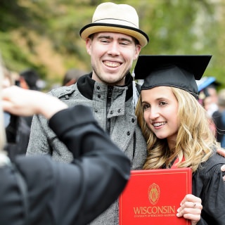 Graduate Nicole Shelley poses for a photo with her boyfriend, Michael Langlois, before the start of the ceremony.