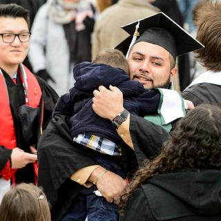 Graduate Salvador Zuniga gives a hug to his nephew before taking his seat on the field.