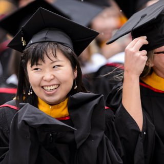 Chilly graduates laugh in disbelief as snow flurries begin to fall in the stadium.