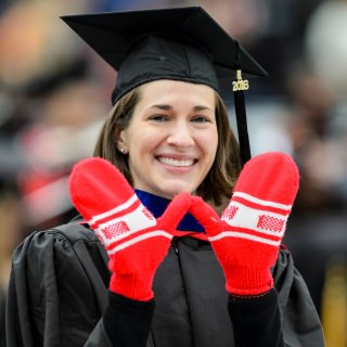 Graduating with an executive MBA in the School of Business, Amy Lee displays a mitten-handed W sign.