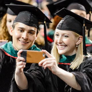 Graduates celebrate with a photo.