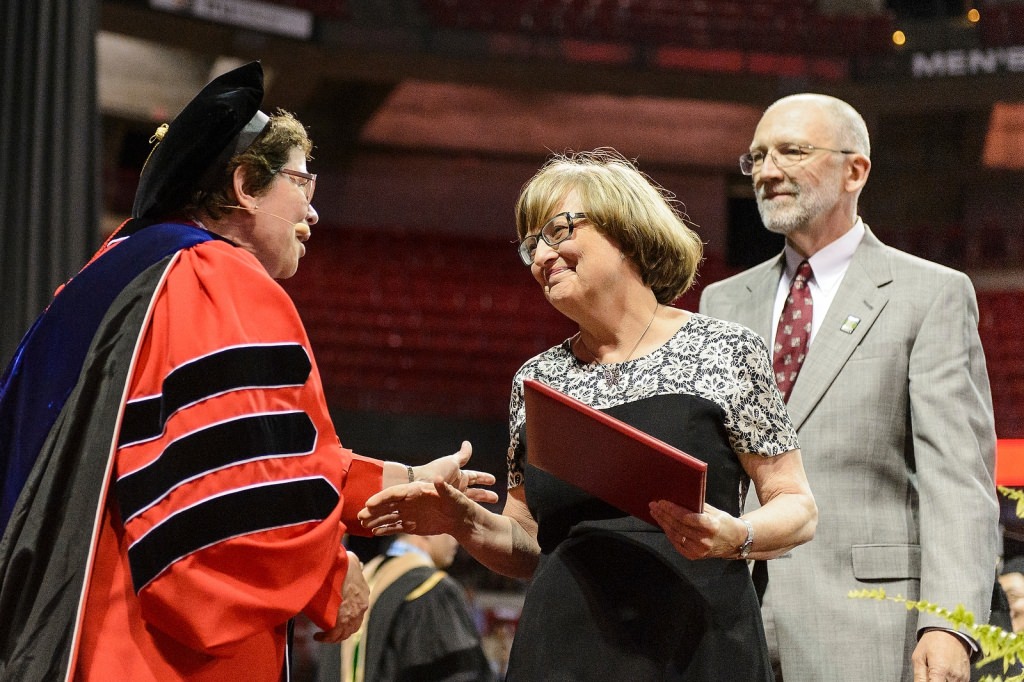 Chancellor Rebecca Blank greets the parents of graduate student Craig Schuff as they received his posthumous degree during Friday's commencement exercises at the Kohl Center. Schuff died in October, months away from completing his Ph.D. in nuclear engineering.