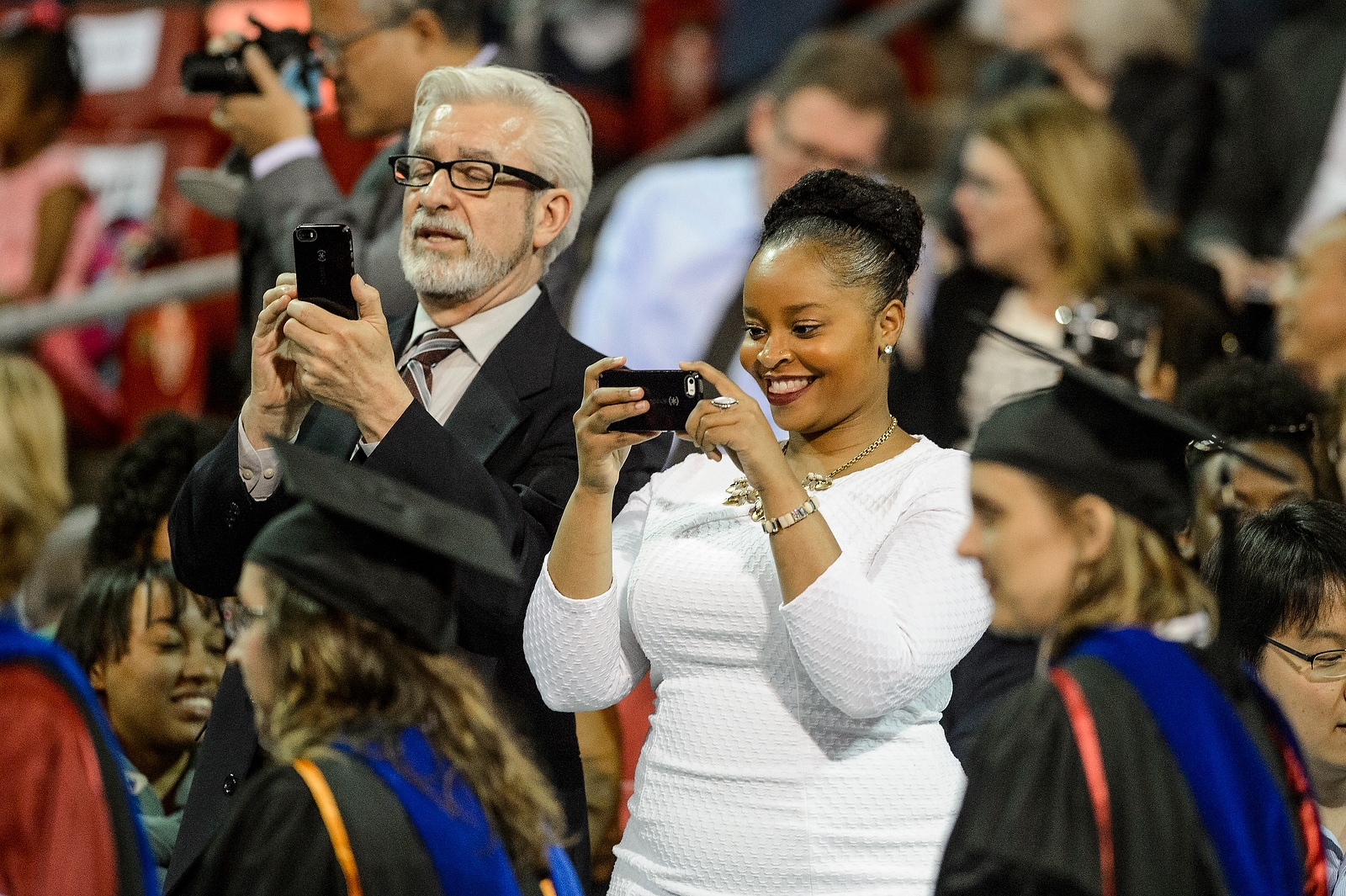 Proud family members capture the moment during commencement exercises for graduate and professional students Friday, May 13, at the Kohl Center.