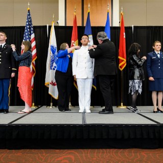 Family members help with a pinning ceremony as graduates from UW-Madison's Army, Navy and Air Force ROTC units participate in an officer commissioning ceremony at Gordon Dining and Event Center. Pictured from left to right are Army Second Lieutenant Josh J. Blusko of Mosinee, Wisconsin; Navy Ensign Benjamin N. Fritz of Lakeville, Minnesota; and Air Force Second Lieutenant Brienna N. Herdrich of West Bend, Wisconsin. The event followed UW-Madison's spring commencement ceremony and formally recognized 37 graduating members as officers in the military.