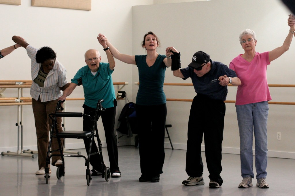 Photo: Group of people with Parkinson's lifting arms