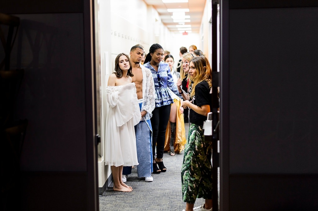 Wearing student-designed clothing, models wait backstage before the start of "Threads: IMPACT."