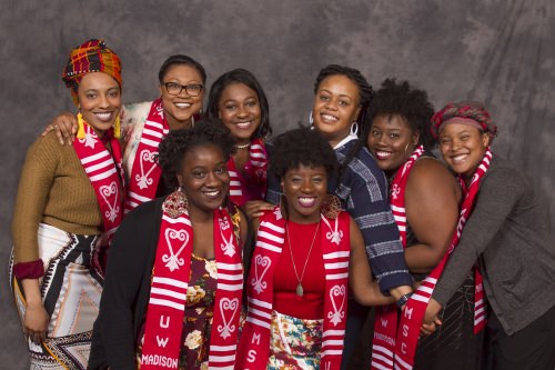 Karla Foster (blue stripes), coordinator for African American Student Academic Services, poses with happy graduates resplendent in their embroidered graduation stoles. 