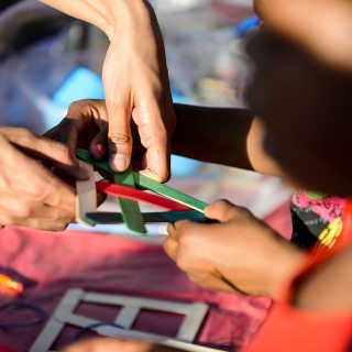 Photo: At a table sponsored by the Wisconsin Institutes for Discovery, children intertwine wooden sticks and learn about the potential for kinetic energy.