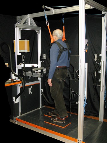 man being held up with straps from above, treadmill underfoot