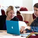 Photo: Two women looking at laptops