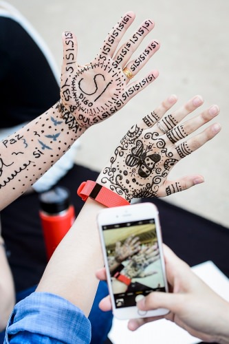 Photo: Two hands with henna pictures and words