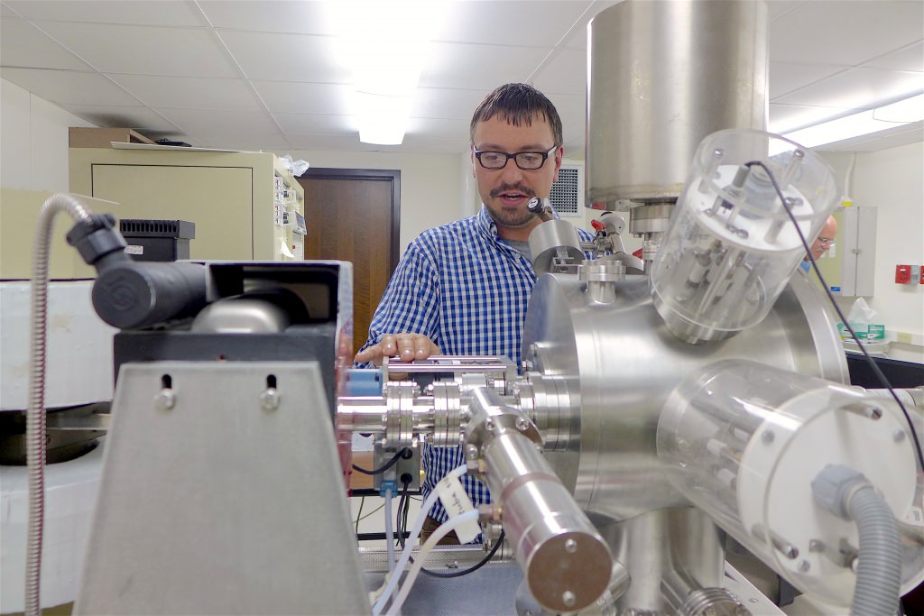 Aaron Satkoski, a scientist in the Department of Geoscience at UW–Madison, with the mass spectrometer used to measure isotopes in rocks from South Africa. 