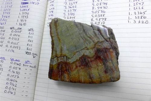  This sample of 3.26-billion-year-old barite shows the granular barite (gray-green areas) that was influenced by ocean water, and bladed barite (vertical black bands) that was by ocean water and water circulating below the sea floor.