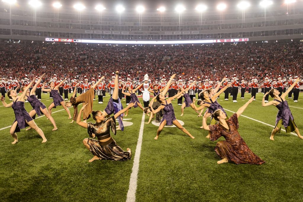 Members of the UW Dance Program perform a rendition of The Lion King with the UW Marching Band during halftime.