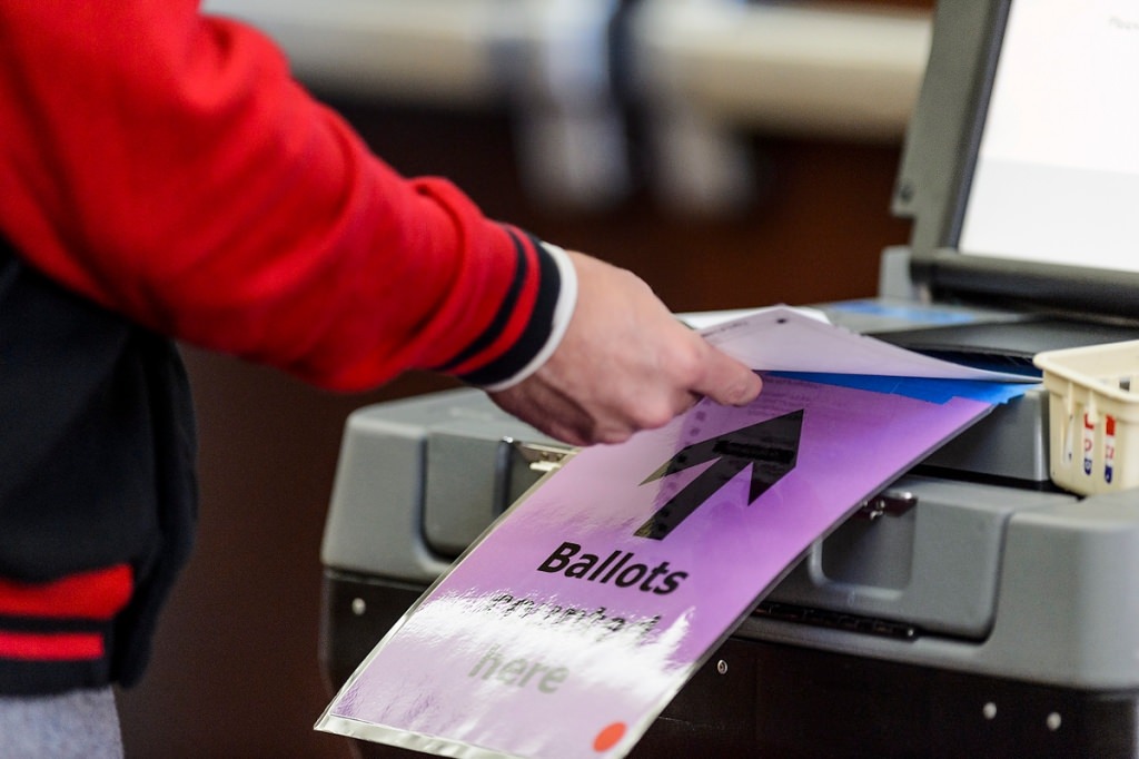 Photo: Voter inserting ballot into counting machine