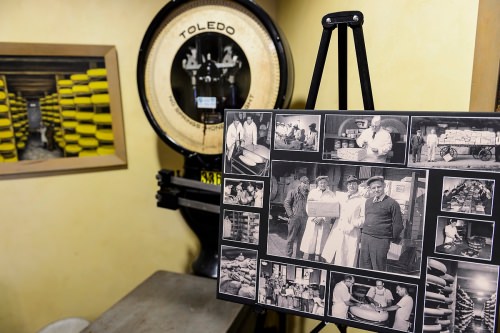 Pictured at center holding a parcel of cheese, company founder Ray Kubly Sr., is featured in a collage of historical company photos and artifacts on display at Colony Brands. 