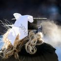 A graduate weathers sub-zero temperature and trudges along a snow-covered walkway leading to UW-Madison's winter commencement ceremony at the Kohl Center.