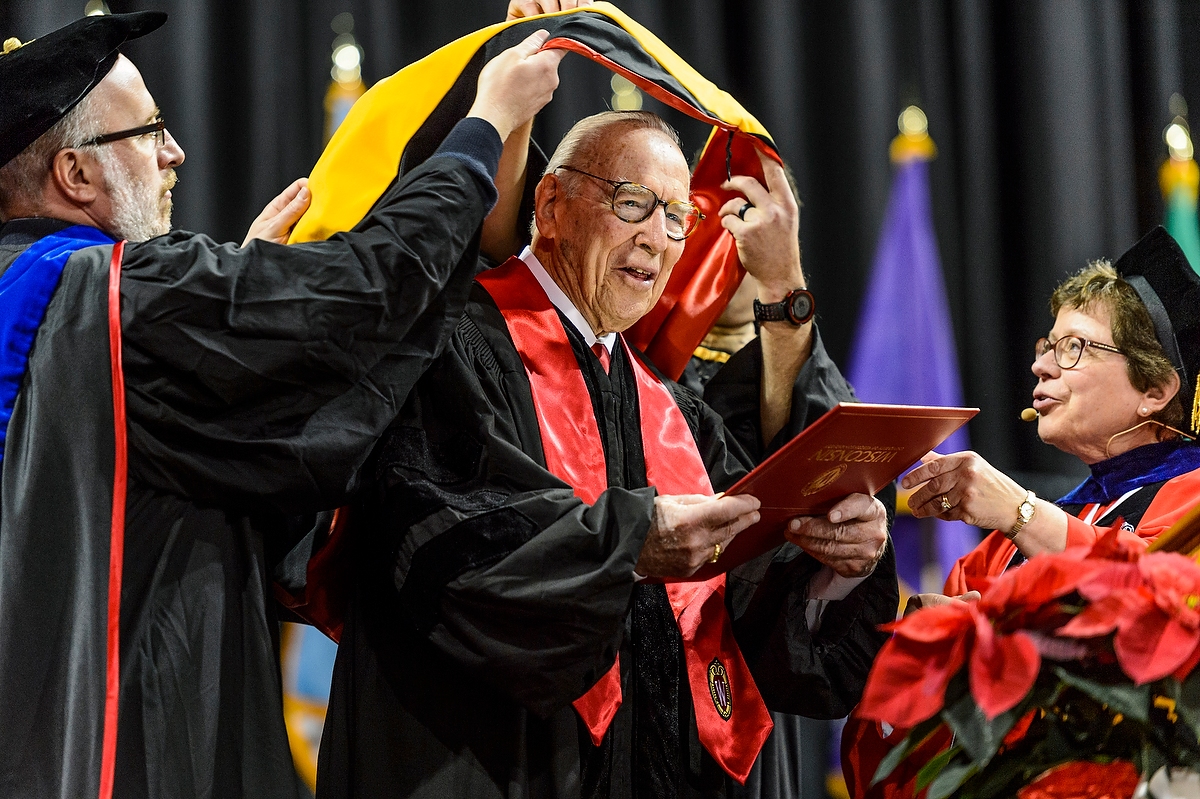 Capt. James A. Lovell Jr., is hooded as he receives an honorary degree from UW–Madison Chancellor Rebecca M. Blank during UW–Madison's winter commencement ceremony at the Kohl Center at the University of Wisconsin–Madison on Dec. 18, 2016. Lovell later spoke and delivered the charge to graduates. The indoor graduation was attended by approximately 1,000 bachelor's and master's degree candidates, plus their guests. (Photo by Jeff Miller/UW-Madison)