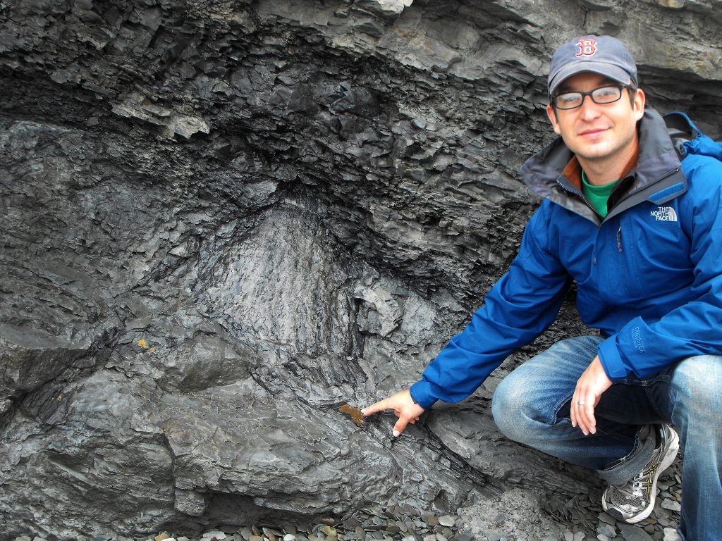 Photo: Jon Husson pointing to fossil