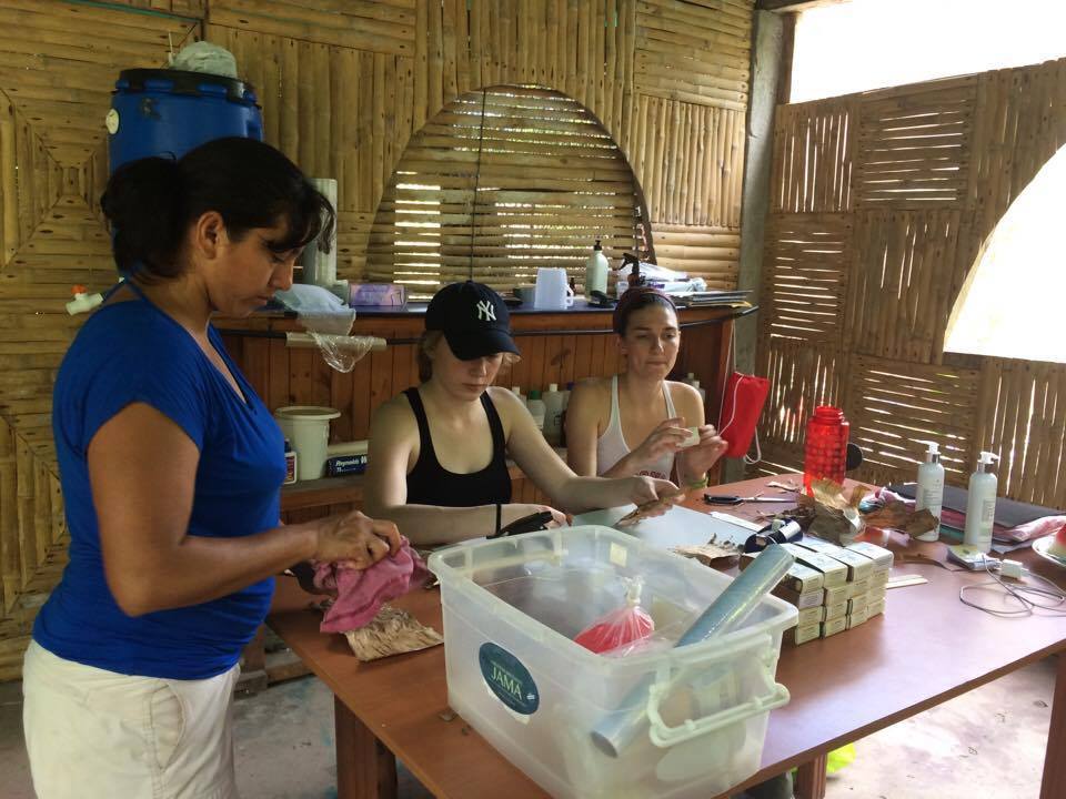 WWBM student director Jen Wagman, center, and operations coordinator Sophia Goldschmidt, right , work with local women to make necklaces during a trip to a Belina Jabon in Ecuador.