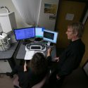 Drs. Cirelli, foreground, and Tononi, right, study an image of a mouse brain taken by a scanning electron microscope, left. Thousands of these images were analyzed for the study published this week in the journal Science.
