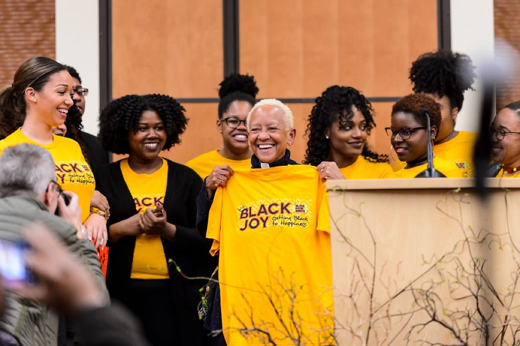 Members of the Black History Month Planning Committee present Giovanni with a commemorative t-shirt following Giovanni's talk.