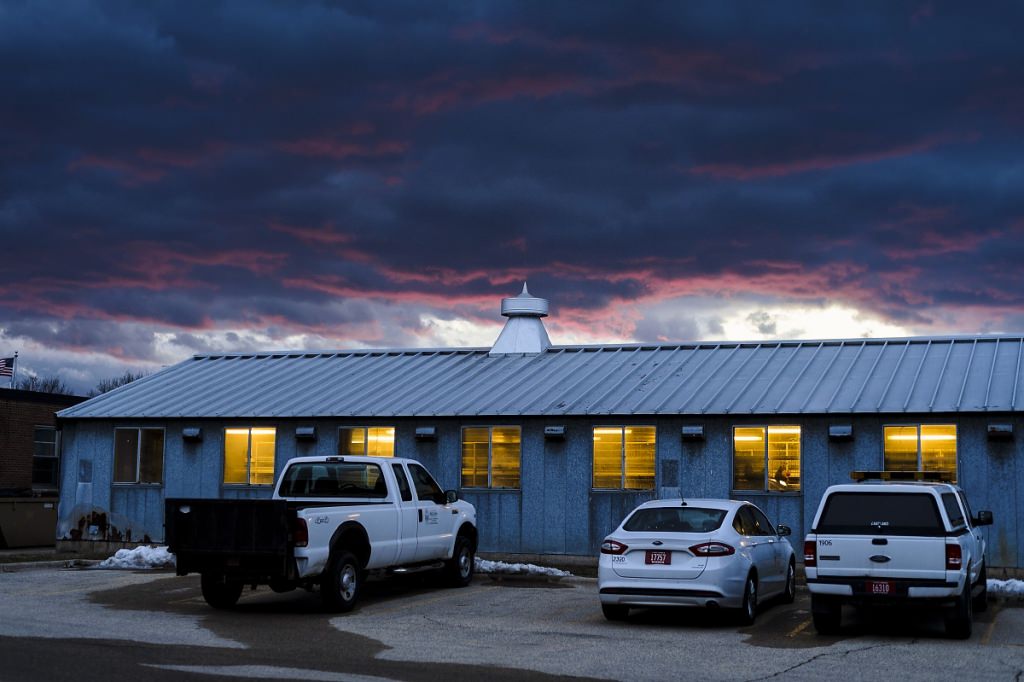 The waning light ofmagenta sunset colors the edge of a cloudy, blue-grey sky as night falls over the metal-roofed Poultry Research Laboratory at the University of Wisconsin-Madison during winter on Feb. 14, 2017. (Photo by Jeff Miller/UW-Madison)