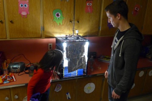 Patrick O’Grady and a student with the light box, which will remain lit for about 40 days, until the Fast Plants produce their own seeds.