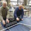 Photo: Men looking at containers on conveyor belt