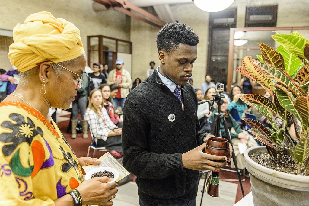 Hazel Symonette, left, program development and assessment specialist in the Division of Student Life, and Marquise Mays (right), chair of the Wisconsin Black Student Union, perform a libation pouring ritual in memory of those who have passed on during a dedication and libation ceremony for the new Black Cultural Center at the Red Gym.