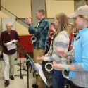 Varsity Band members applaud director Mike Leckrone as he returns to work March 15 following double bypass surgery.