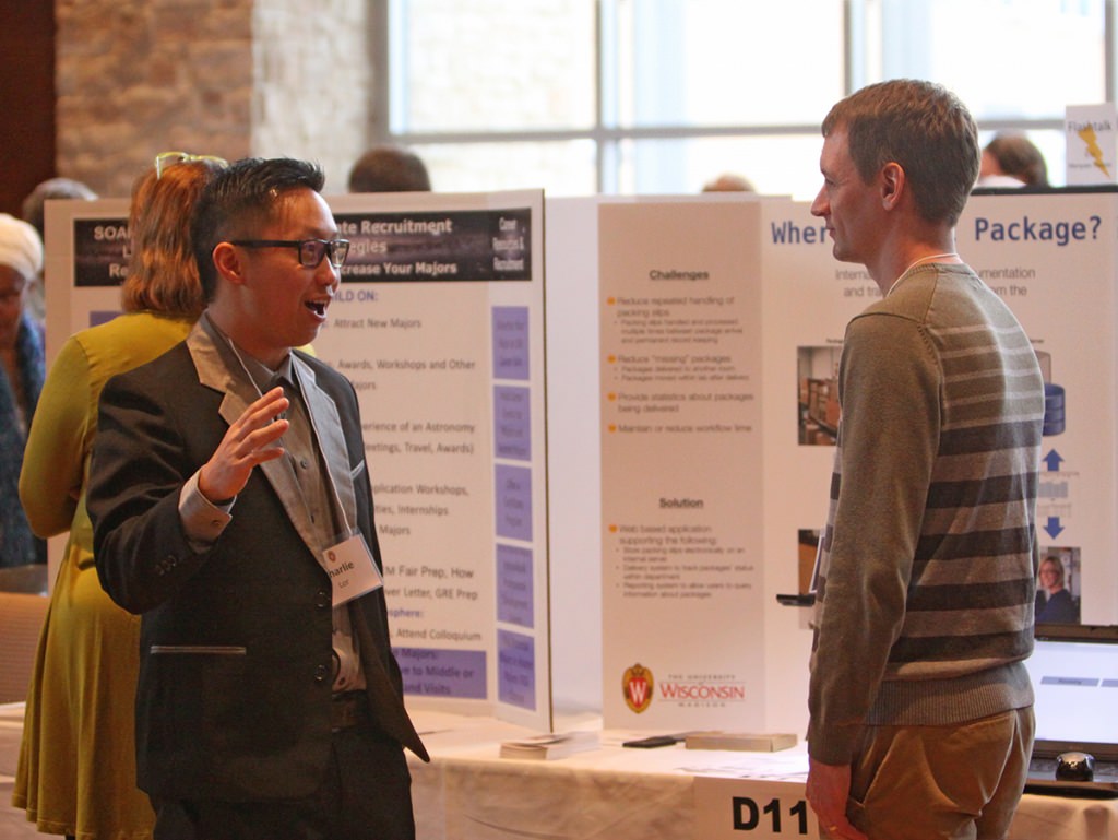 Photo: Two men discussing a poster