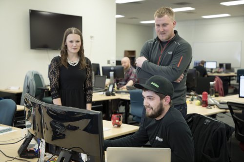 At Foot Locker's offices in Wausau, “product owner” Jacklyn Cummins and “scrum master” John Hocker discuss a fine point of software development with “product manager” Jordan Meyer. 