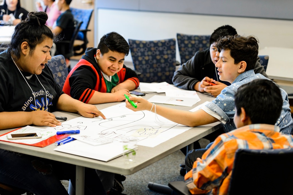 Photo: Students at table drawing neighborhood maps