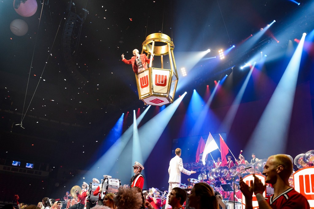 Suspended overhead in a wired basket, band director Mike Leckrone, 80 and now in his 47th year at UW-Madison, makes a flying entrance across the stage as the band performs toward the end of the 43rd annual UW Varsity Band Spring Concert at the Kohl Center at the University of Wisconsin-Madison on April 20, 2017. This year's concert, entitled "Nobody Does It Better: 20 Years at the Kohl," comes after Leckrone's return to campus following recovery from a medical procedure this past winter. (Photo by Jeff Miller/UW-Madison)