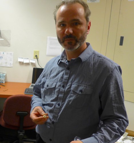 Dan Butz, a scientist at Isomark, a UW–Madison spinoff, holds a fitting that connects the sample container to Isomark’s analytical instrument. 