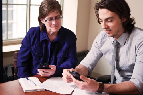 Researchers Lisa Dillenberg and Andrew Isham working on the development of the A-CHESS app.